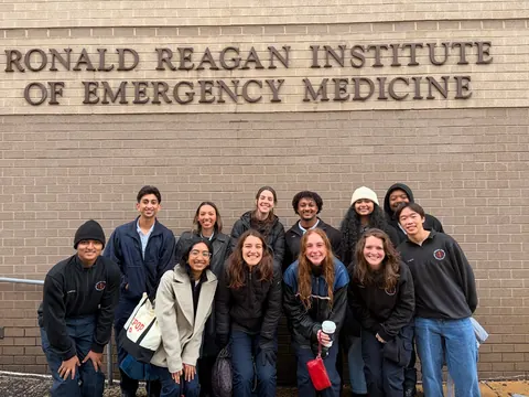 Members of the Texas A&M Emergency Care Team posing together in front of a wall reading “Ronald Reagan Institute of Emergency Medicine”.